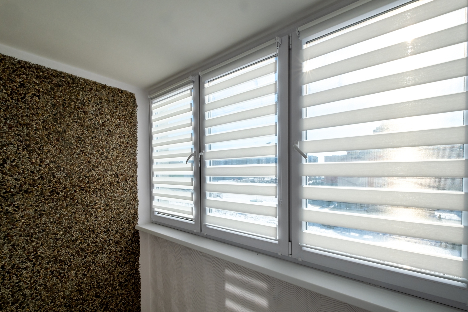 Fenster mit Blenden und eine Wand aus Stein